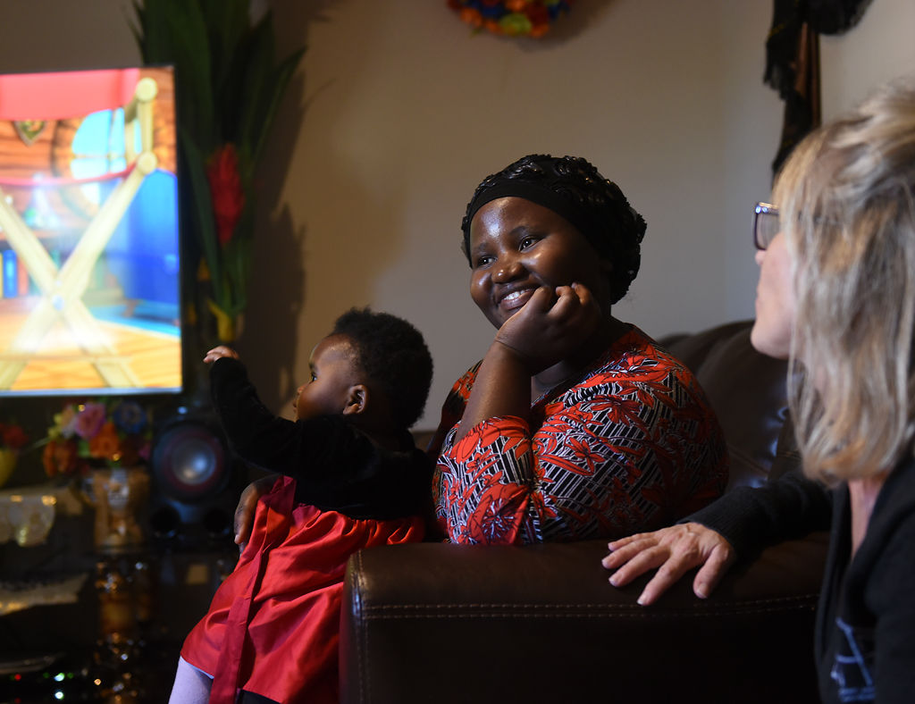 Bukuru Nihabose, center, talks to Samantha Christian in her new apartment